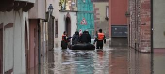 Die überflitete Wertheimer Altstadt. Im Hintergrund sind vier Männer mit einem Hochwasserrettungsboot zu sehen.