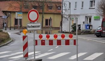 Absperrbarken mit Hinweisschild "Hochwasser"