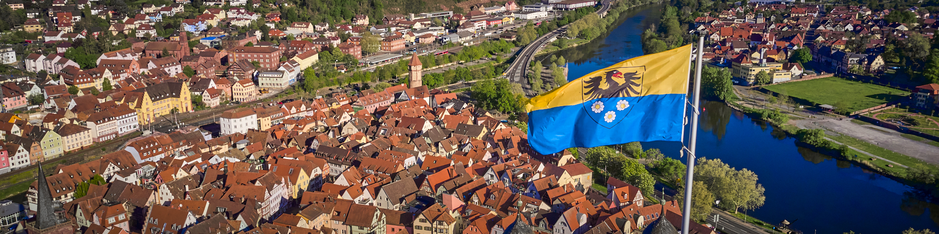 Luftaufnahme der Altstadt. Im Vordergrund wehrt die Stadtflagge von Wertheim.