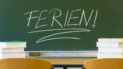 grüner Tafel mit dem Schriftzug Ferien