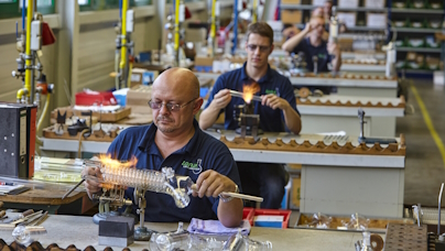 Das Foto zeigt einen Glasapparatebauer bei der Arbeit